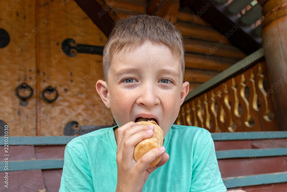 A boy sitting on wooden stairs and eating icecream. A boy sitting on wooden stairs and eating icecream.