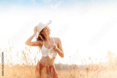 Young attractive girl in field at sunset