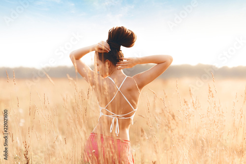 Fotografia Young attractive girl in field at sunset