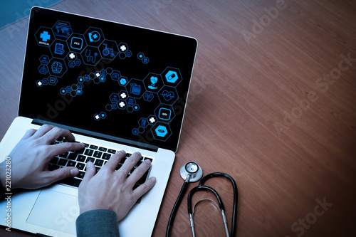 top view of Medicine doctor hand working with modern computer and blank screen on wooden desk as medical concept