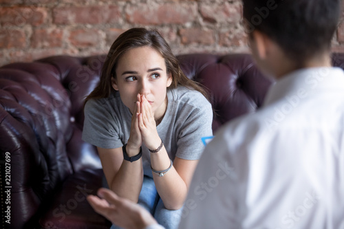 Young woman visiting therapist counselor. Girl feeling depressed, unhappy and hopeless, needs assistance. Serious disease, unwilling pregnancy, abort or death of loved one, addiction to drugs concept photo