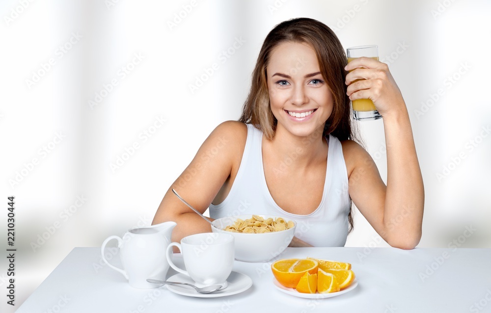 Attracive young woman enjoying tea and fruits on breakfast Attracive young woman enjoying tea and fruits on breakfast