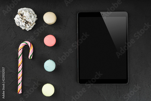 Wallpaper Mural Digital tablet with sweet macarons, lollipop and biscuit on stone background. Copy space, flat lay Torontodigital.ca