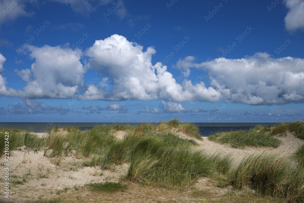 Dünen und Sand und Meer und blauer Himmel und weiße Wolken - Stockfoto