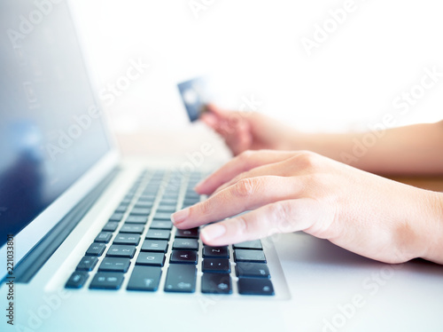 female hands holding credit card and using laptop for online shopping 
