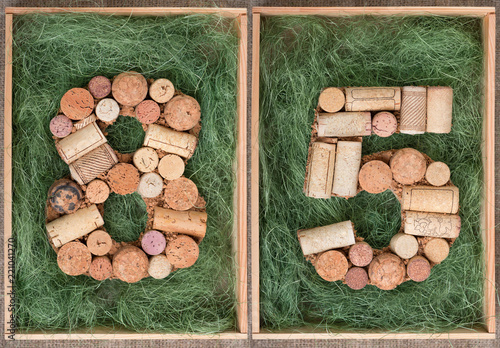 Number 85 eighty five made of wine corks on green background in wooden box