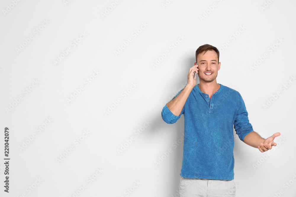 Young man talking on phone against white background. Space for text Young man talking on phone against white background. Space for text