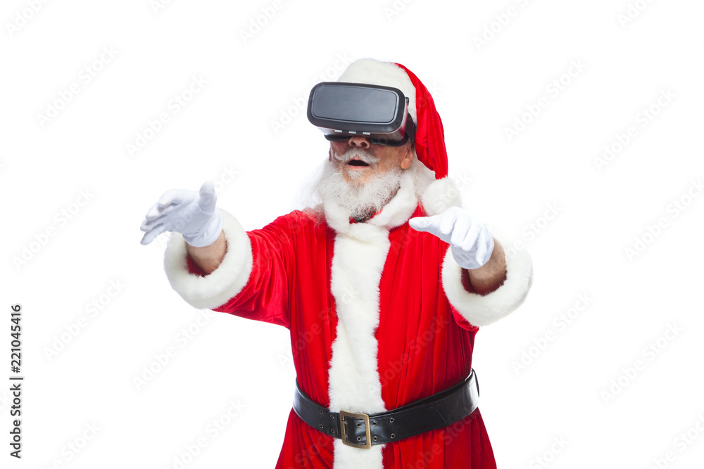 Christmas. Santa Claus in black virtual reality glasses makes gestures with his hands. Surprise, emotion. New technology. Isolated on white background. Christmas. Santa Claus in black virtual reality glasses makes gestures with his hands. Surprise, emotion. New technology. Isolated on white background.
