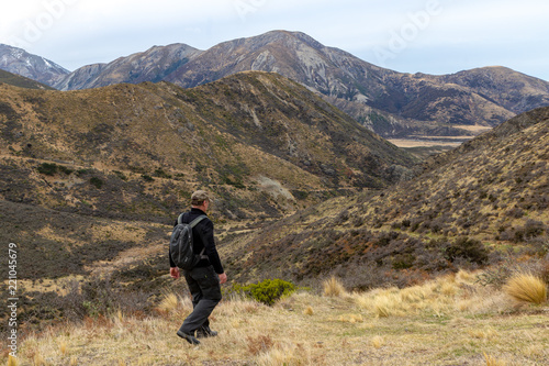 An older male hiking on tracks in the hills in New Zealand photo