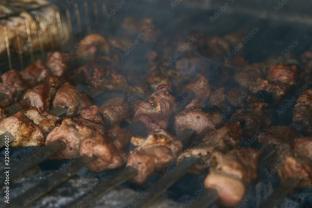 Roasted meat cooked at barbecue. Grilled kebab cooking on metal skewer. BBQ fresh beef meat chop slices. Traditional eastern dish, shish kebab. Grill on charcoal and flame, picnic, street food Roasted meat cooked at barbecue. Grilled kebab cooking on metal skewer. BBQ fresh beef meat chop slices. Traditional eastern dish, shish kebab. Grill on charcoal and flame, picnic, street food