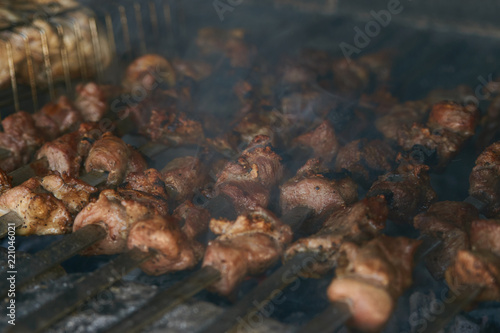 Roasted meat cooked at barbecue. Grilled kebab cooking on metal skewer. BBQ fresh beef meat chop slices. Traditional eastern dish, shish kebab. Grill on charcoal and flame, picnic, street food