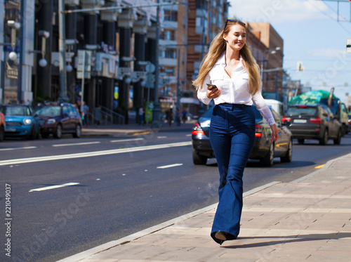 Young blonde business woman in blue jeans and white shirt