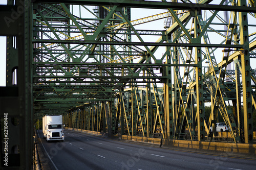 Big rig white semi truck transporting semi tailer on Columbia interstate lifting sectional bridge