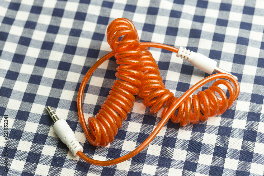 aux cable on the background of checkered fabric aux cable on the background of checkered fabric