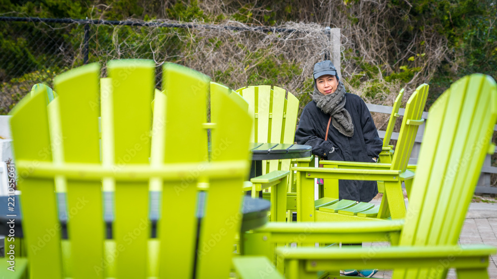 Woman standing by large Green Chairs