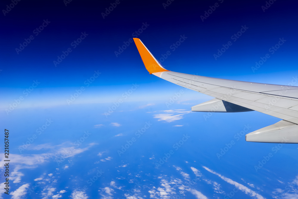 Obraz premium airplane wing over the blue cloud sky
