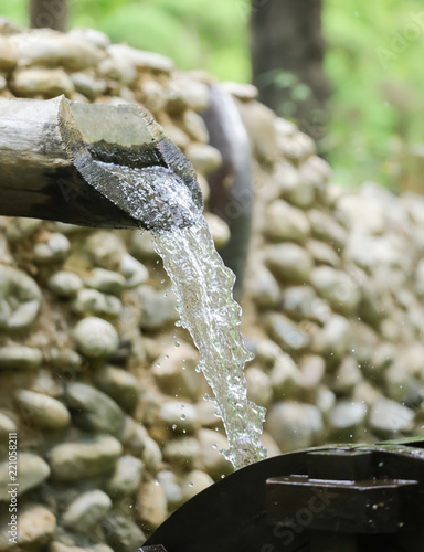 Фотография water flows from a pipe or water gushing out of the pipe close up