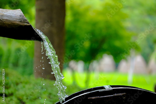Принти на полотні water flows from a wooden pipe or water gushing out of the pipe close up