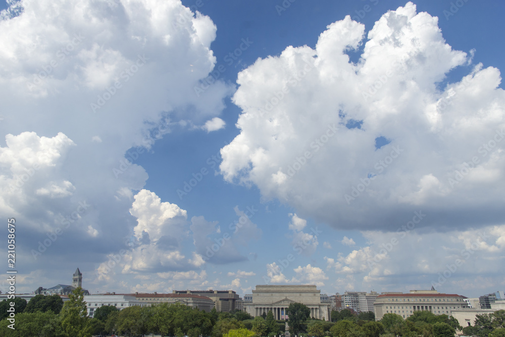 Cumulus clouds fill the sky over the National Mall in Washington, DC. National Archives are at center..