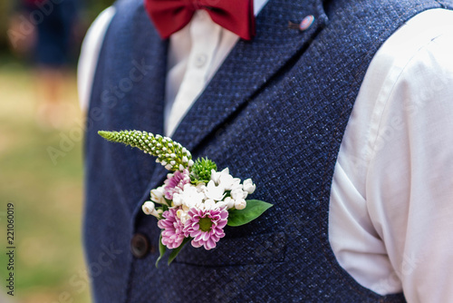 Fototapeta Pink flowers boutonniere flower groom wedding coat with vest