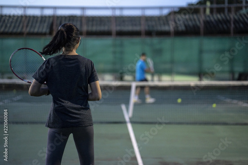 Tennis players playing a match on the court on a sunny day © Danupol