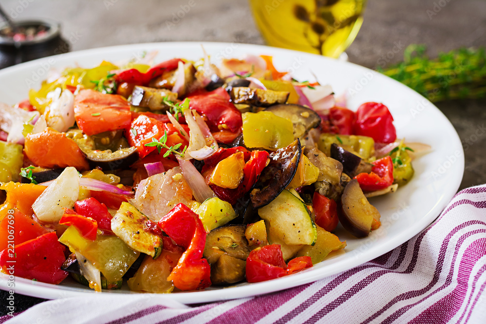 Baked vegetables on white plate. Eggplant, zucchini, tomatoes, paprika and onions