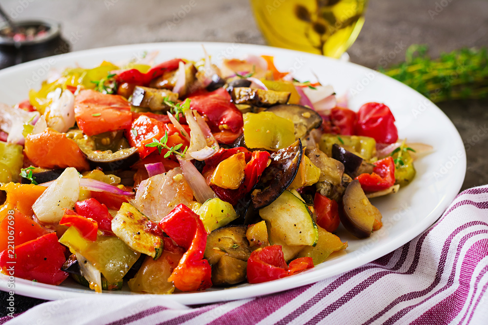 Baked vegetables on white plate. Eggplant, zucchini, tomatoes, paprika and onions Baked vegetables on white plate. Eggplant, zucchini, tomatoes, paprika and onions