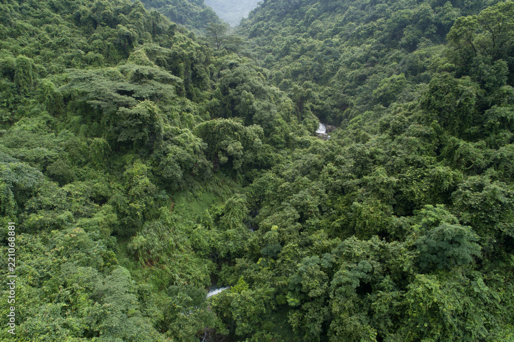 Fototapeta premium Aerial View of Waterfall in the Tropical Rainforest Mountains