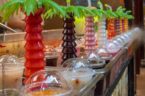 Section of freshly prepared juices from tropical fruits in shop-window counter