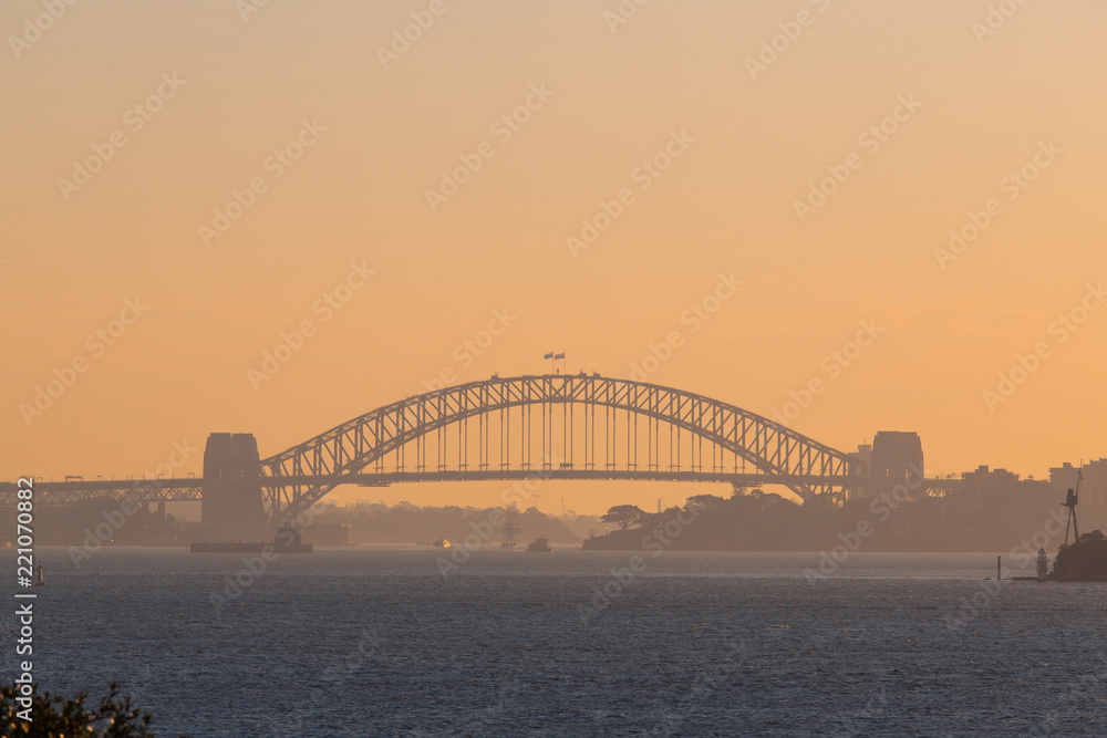 Naklejka premium Sydney Harbour Bridge in a hazy sunset sky.