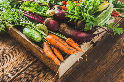 Fresh vegetable, organic produce on farmer market. Vegetables in the box on wooden table.