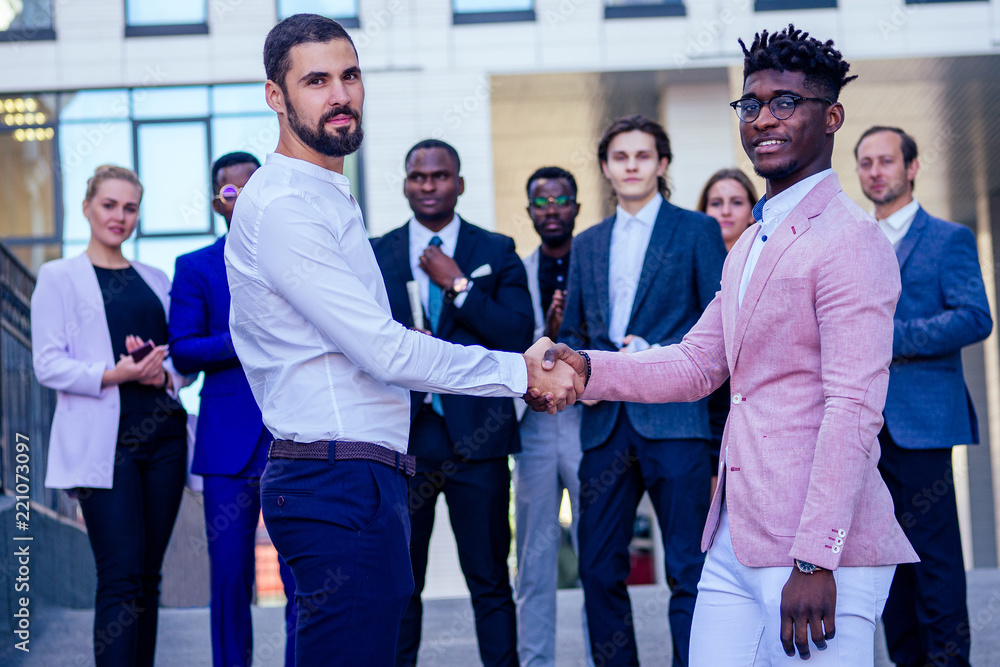 Multiracial african and caucasian men handshaking at meeting and making deal shaking hands to white businessman multinational and multiethnic corporate business people . Greeting Deal Concept Multiracial african and caucasian men handshaking at meeting and making deal shaking hands to white businessman multinational and multiethnic corporate business people . Greeting Deal Concept