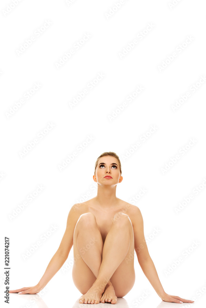 Young naked woman sitting on the floor Young naked woman sitting on the floor