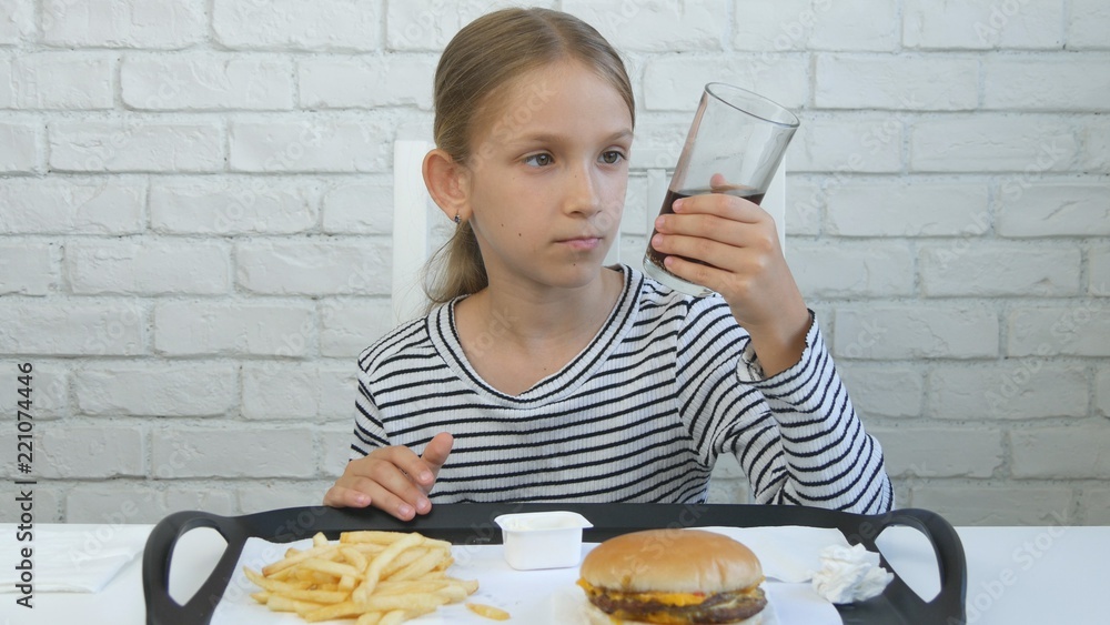 Child Eating Hamburger in Restaurant, Kid and Fast Food, Girl Drinking Juice Child Eating Hamburger in Restaurant, Kid and Fast Food, Girl Drinking Juice