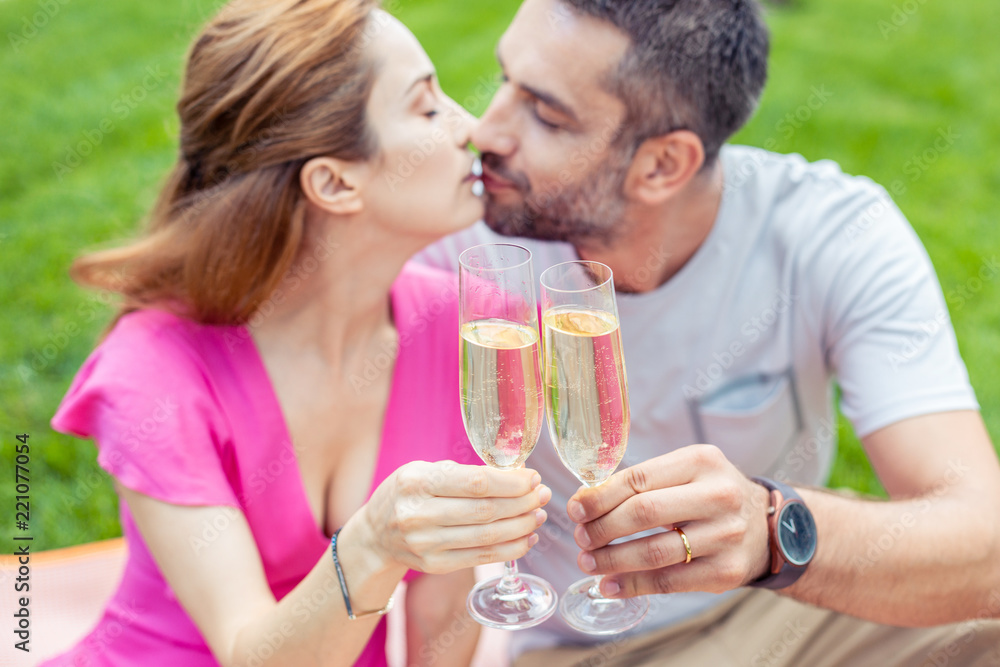 Reason to celebrate. Selective focus of two glasses with champagne being clinked together while celebrating their anniversary Reason to celebrate. Selective focus of two glasses with champagne being clinked together while celebrating their anniversary