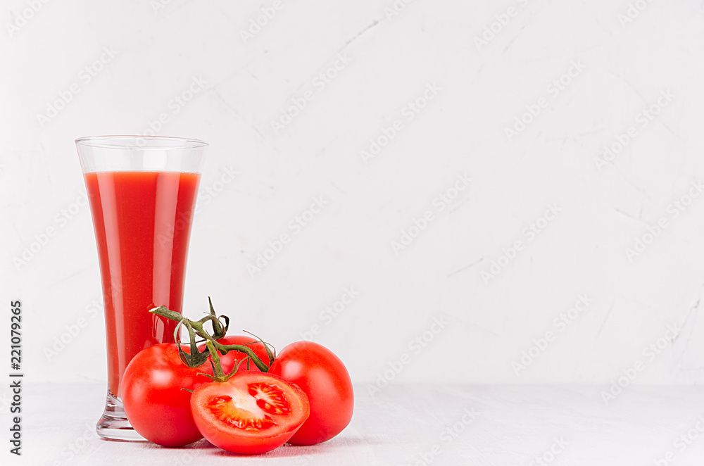 Tomato juice in glass with branch tomatoes and juicy slice on white wood table, copy space. Tomato juice in glass with branch tomatoes and juicy slice on white wood table, copy space.