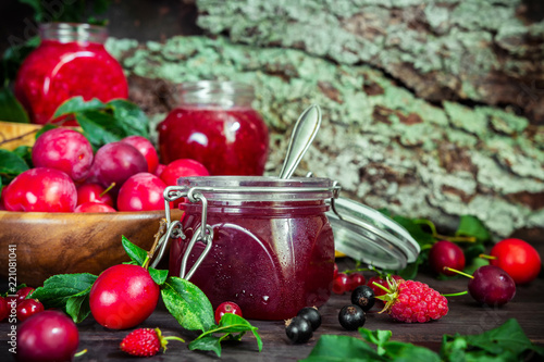 homemade jam in a glass jar of various berries and plums on a dark  background.Healthy food, diet, detox, clean eating and vegetarian concept with copy space.