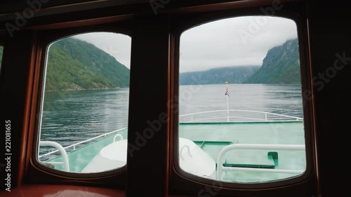 Wallpaper Mural View through the porthole of the ship to the picturesque Norwegian fjord. In front you can see the ship's nose and the Norwegian flag Torontodigital.ca