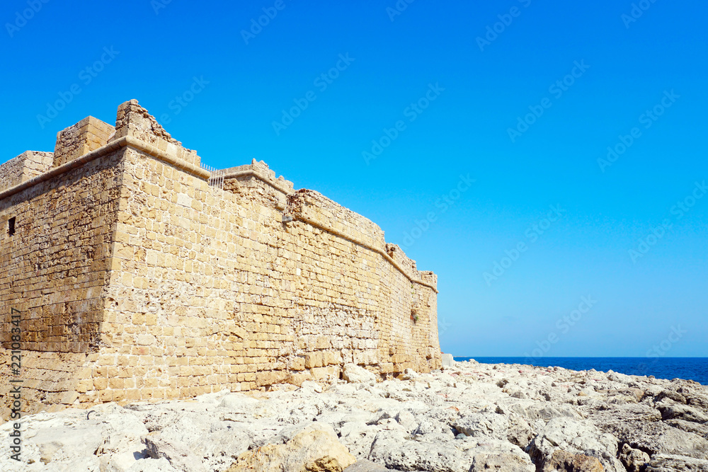 Medieval Knight Castle on the Mediterranean coast in sunny summer day