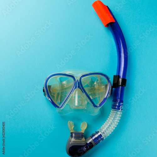 Diving equipment. Snorkeling mask and tube on blue background. Colorful background. Top view. Copy space. Flat lay
