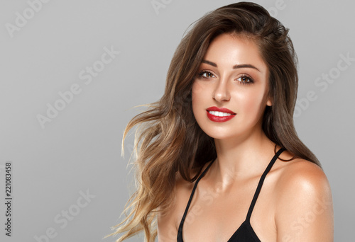 Beautiful brunette with long hair red lips tanned skin