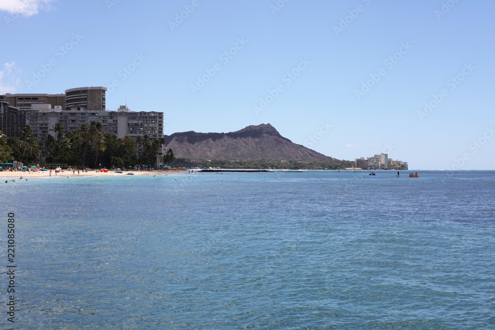 Blue water coast with a mountain in the city ashore