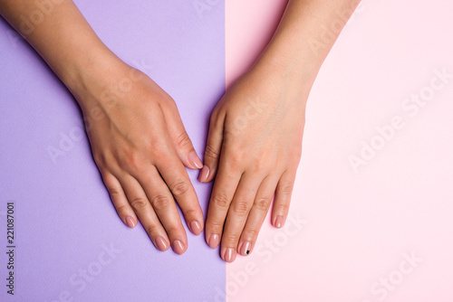 Stylish trendy women manicure. Hand and nail care. Female hands with perfect pastel pink nails on colorful background. Manicured woman hands. Girl in a nail salon receiving manicure. Beauty concept. © volurol