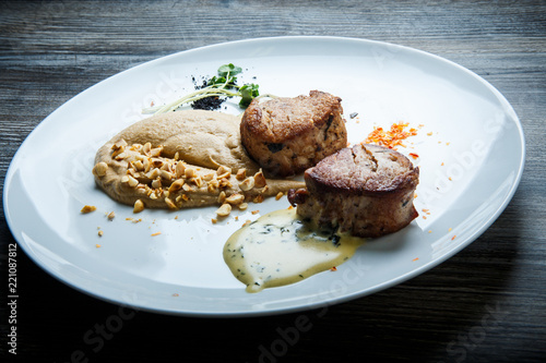 two tasty pieces of grilled meat with puree and sauce