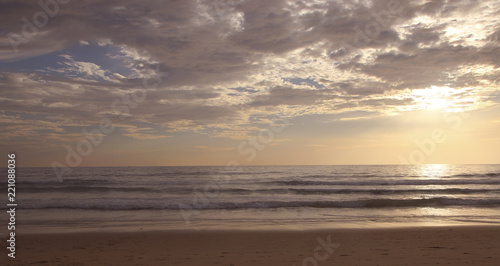 Beautiful sunset on Karon beach. The surf pounds the shore. Phuket, Thailand