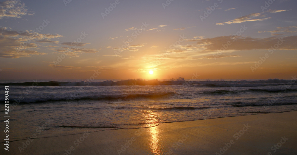 Beautiful sunset on Karon beach. The surf pounds the shore. Phuket, Thailand