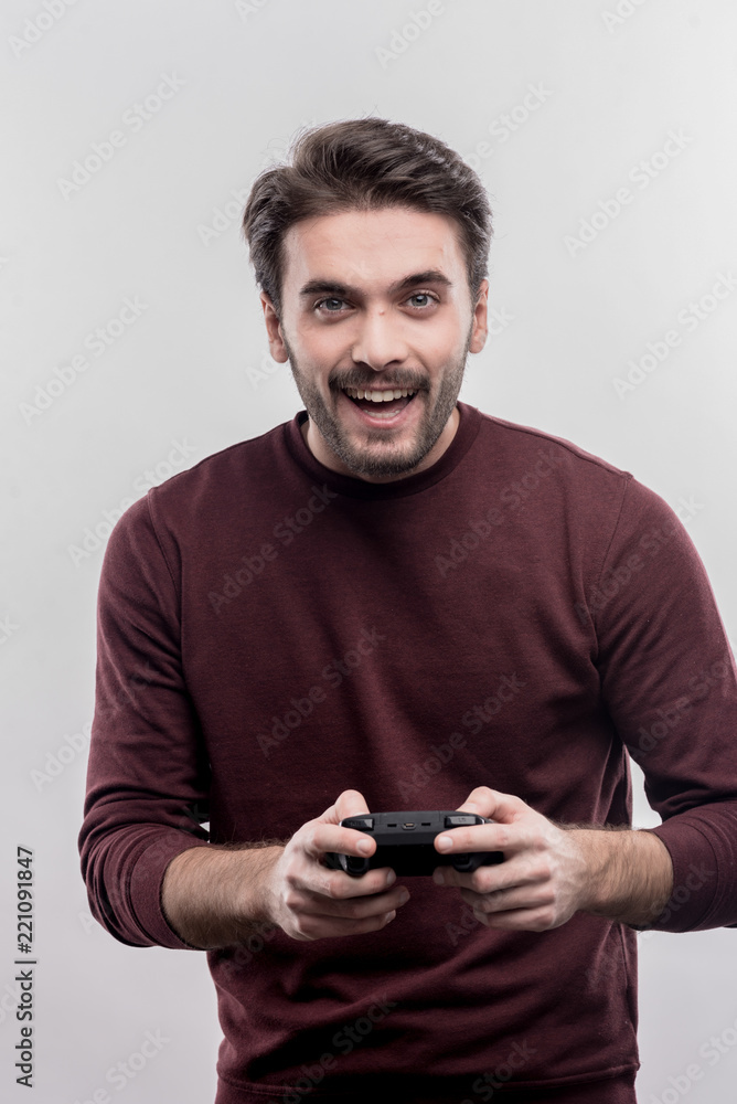 Man with joystick. Emotional handsome young man holding joystick while enjoying video games on image without face retouching Man with joystick. Emotional handsome young man holding joystick while enjoying video games on image without face retouching