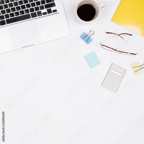 Home office desk workspace with coffee cup, glasses and laptop on white background. Flat lay for entrepreneur.  Small business concept. Top view.