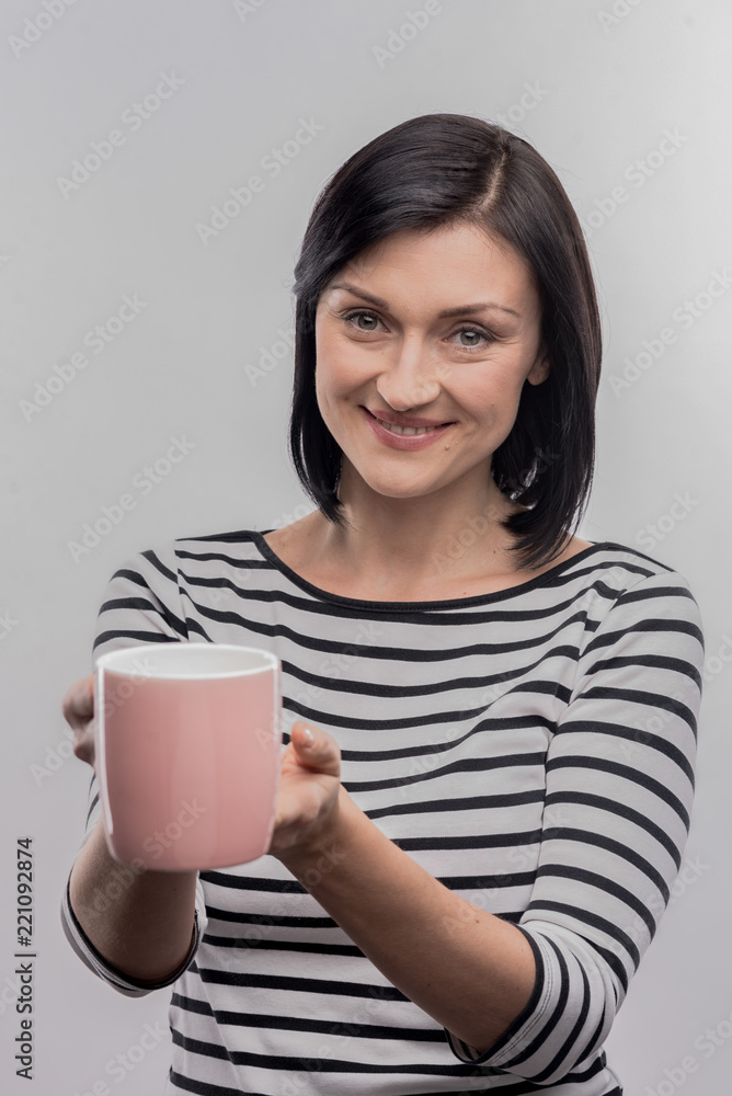 Striped shirt. Image without face retouching with beaming beautiful woman wearing striped shirt holding pink cup of coffee Striped shirt. Image without face retouching with beaming beautiful woman wearing striped shirt holding pink cup of coffee