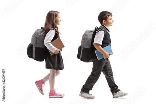Schoolgirl and schoolboy with backpacks walking